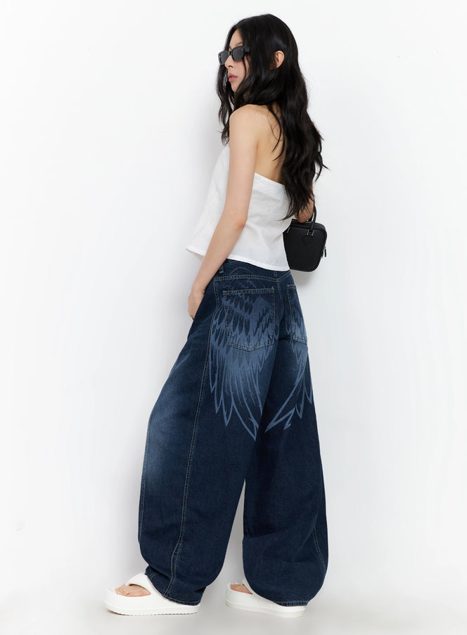 LEWKIN Sohee Angel Wing Print Wide-Leg Jeans IG508 in dark blue, back-angle view on model, washed cotton wide-fit silhouette with bold angel wing print, styled with white tube top and mini bag.